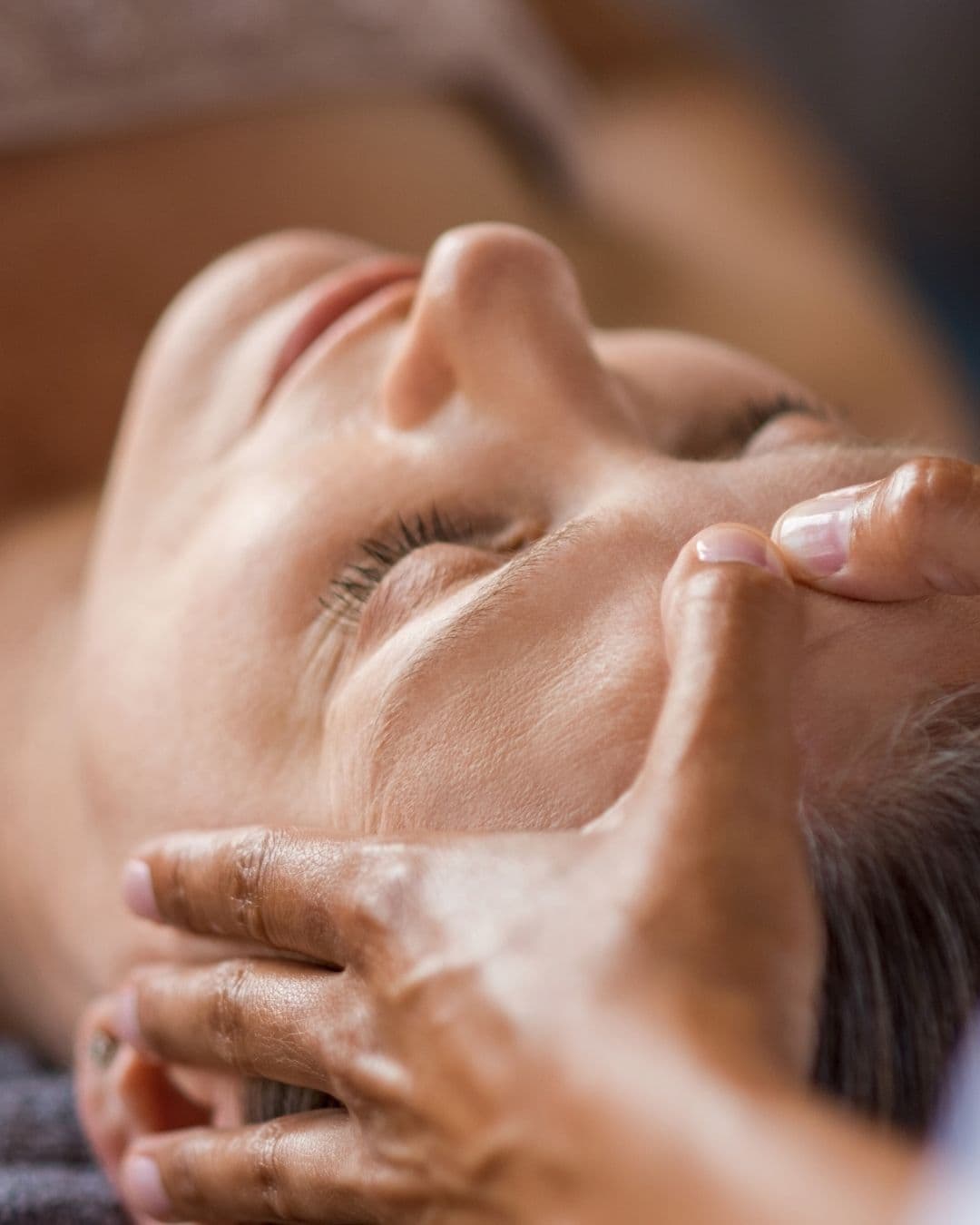 Hände massieren Gesichtscreme ins Gesicht ein, entspannende Kosmetikbehandlung, Lymphdrainage