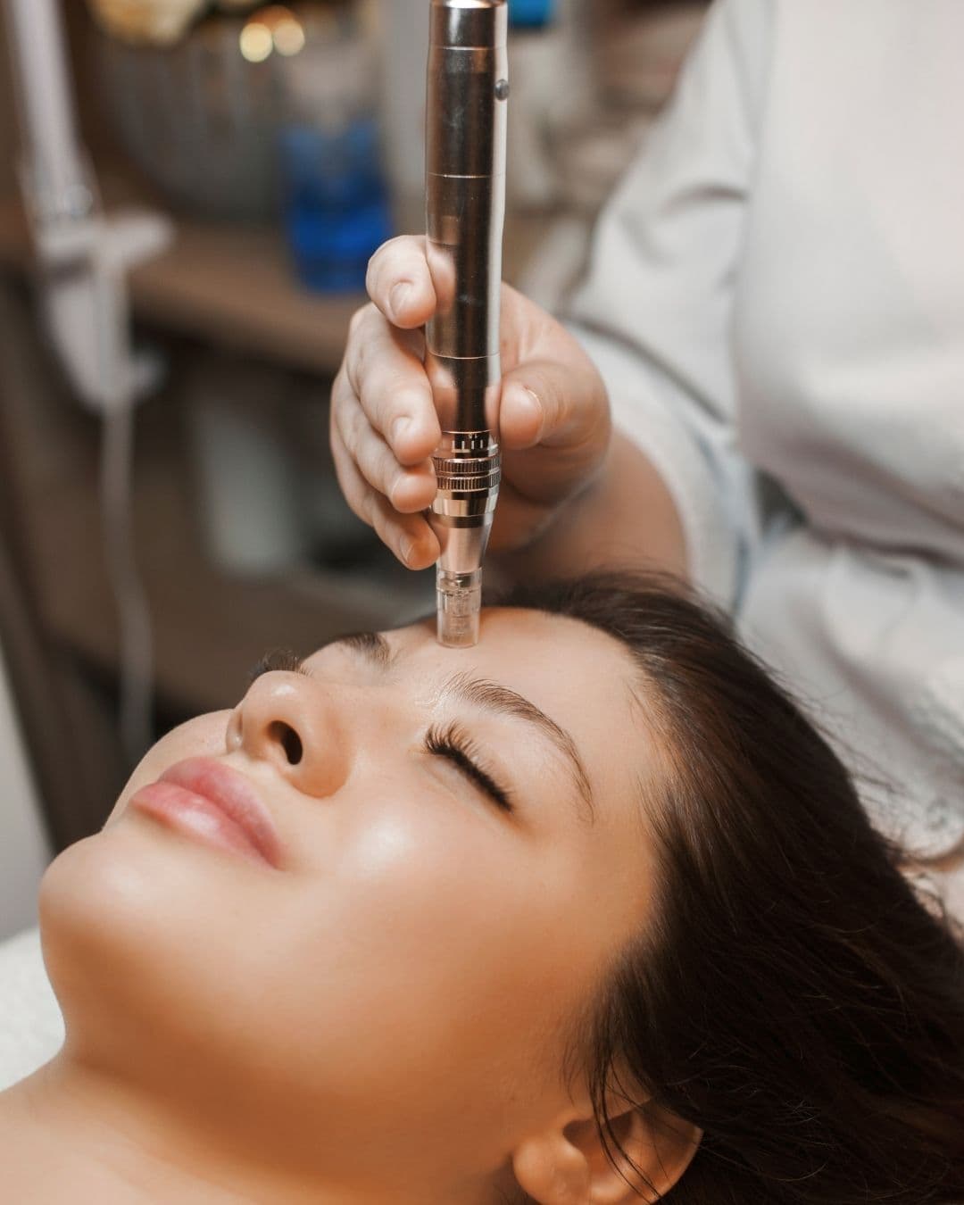 Kosmetikerin führt Needling-Behandlung auf Frauengesicht durch, professionelle kosmetische Gesichtsbehandlung